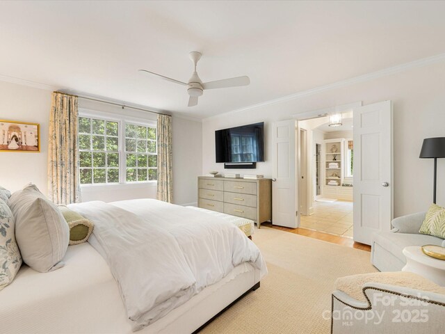 bedroom with ornamental molding, light wood-style flooring, and ceiling fan