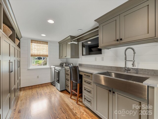 kitchen with washer and dryer, a sink, light wood-style flooring, recessed lighting, and gray cabinets