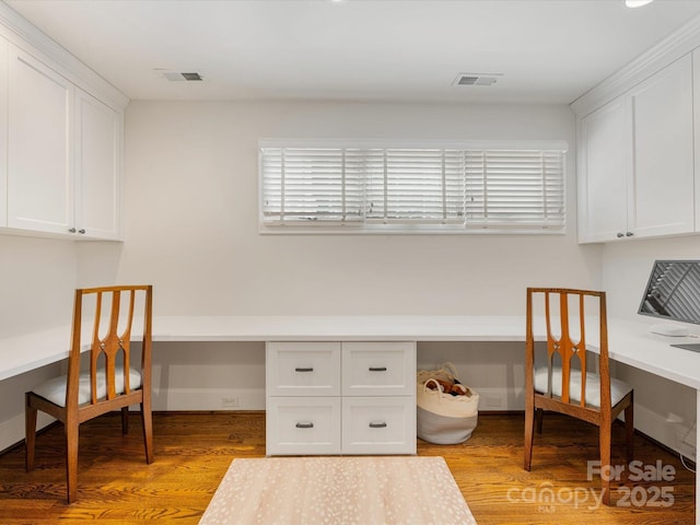 office featuring built in desk, light wood-style flooring, and baseboards