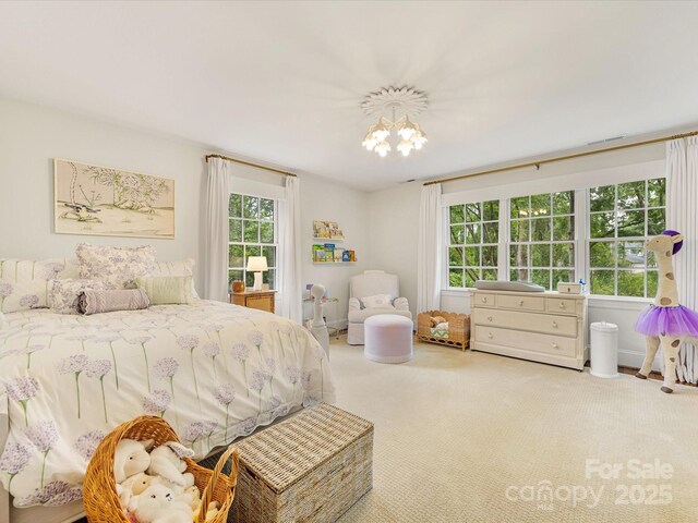 bedroom featuring multiple windows, carpet floors, and a chandelier