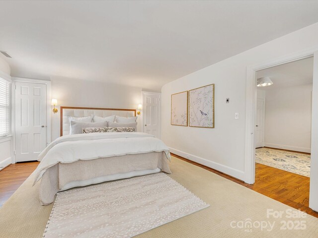 bedroom with wood finished floors and baseboards