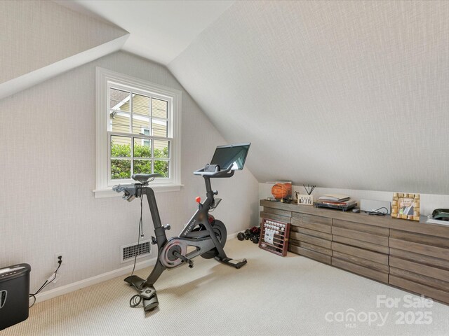 workout area featuring lofted ceiling, carpet, and baseboards