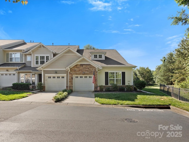 view of front facade featuring driveway, a front yard, a garage, fence, and stone siding