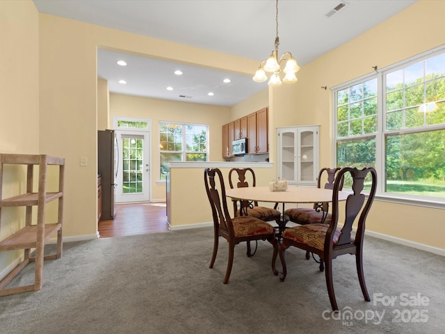 carpeted dining space with a chandelier, baseboards, visible vents, and recessed lighting