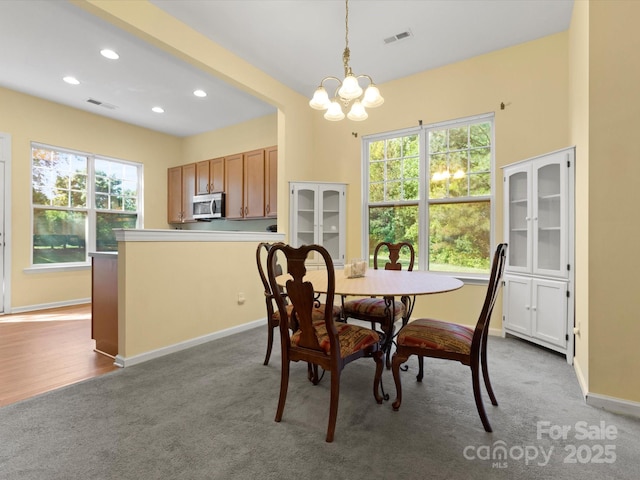 dining room with visible vents, carpet flooring, and a notable chandelier