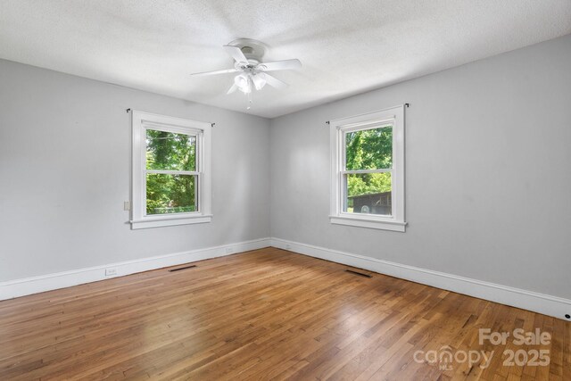 3418 Sulphur Springs Rd NE, Hickory, NC 28601 - spare room featuring healthy amount of natural light, wood finished floors, ceiling fan, baseboards, and a textured ceiling