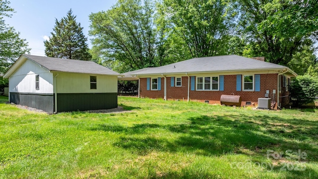 3418 Sulphur Springs Rd NE, Hickory, NC 28601 - back of property with cooling unit, a lawn, heating fuel, an outdoor structure, and a chimney