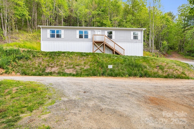 manufactured / mobile home with a wooded view and stairway