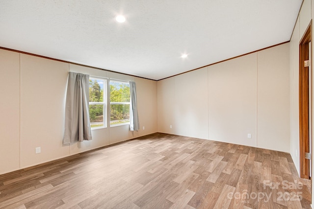 spare room featuring ornamental molding, light wood finished floors, and recessed lighting