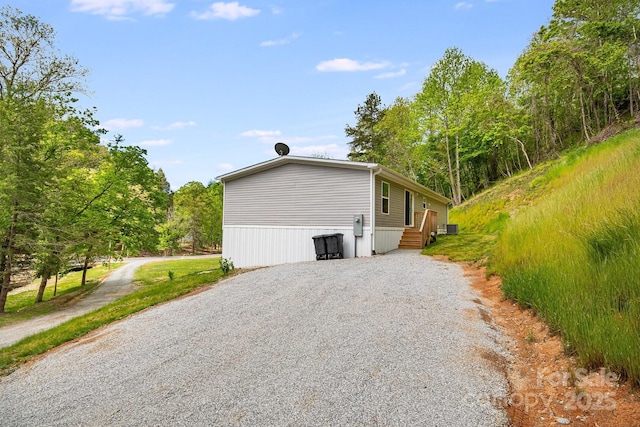 view of side of property with gravel driveway