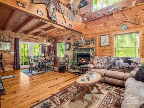 living area featuring wood walls, wood finished floors, and a wealth of natural light