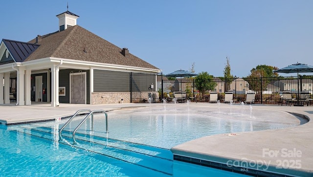 pool with a patio and fence