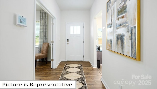 doorway featuring baseboards and wood finished floors