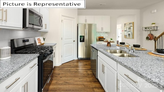 kitchen with tasteful backsplash, a sink, stainless steel appliances, white cabinetry, and dark wood-type flooring