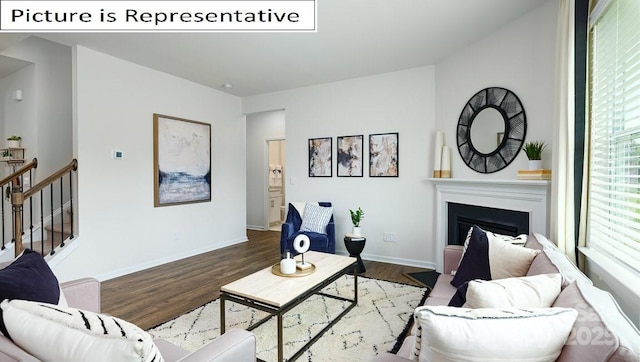 living room featuring stairs, baseboards, wood finished floors, and a fireplace