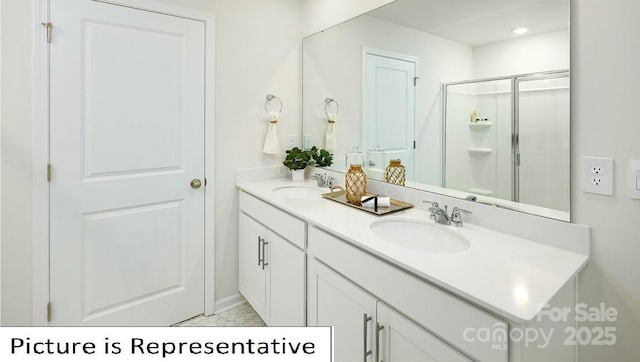 bathroom with double vanity, a sink, baseboards, and a shower stall