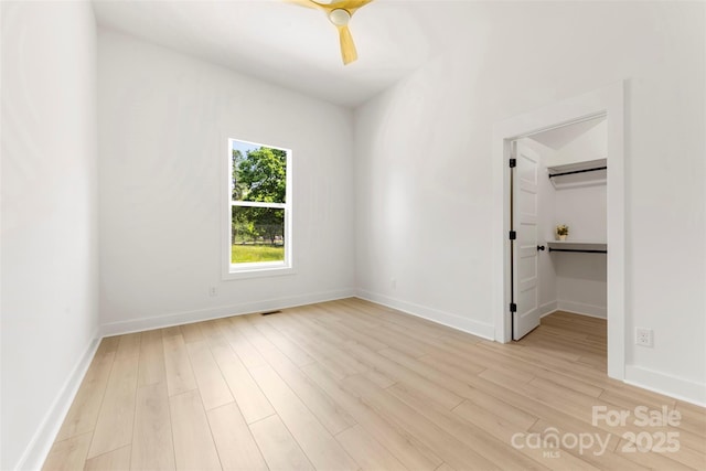 unfurnished bedroom featuring baseboards, a ceiling fan, light wood finished floors, and visible vents