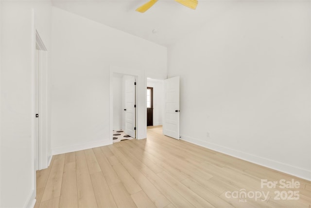 empty room with light wood-style floors, baseboards, and ceiling fan