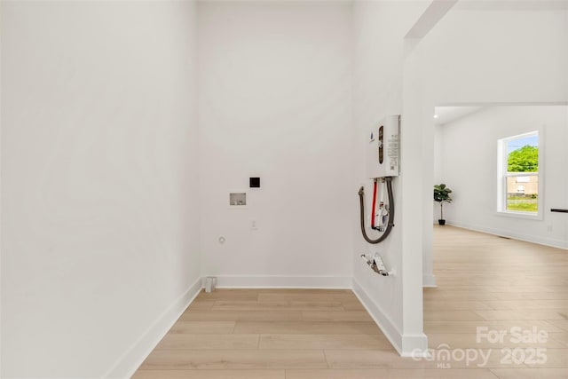 laundry area with baseboards, washer hookup, hookup for a gas dryer, and light wood-type flooring