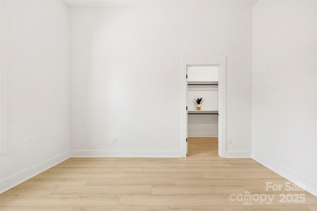 empty room featuring baseboards and light wood-type flooring