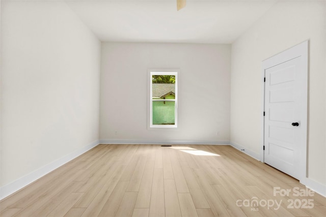 unfurnished room featuring baseboards and light wood-type flooring