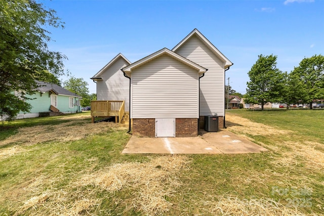 back of house with central air condition unit, a deck, crawl space, a patio area, and a lawn
