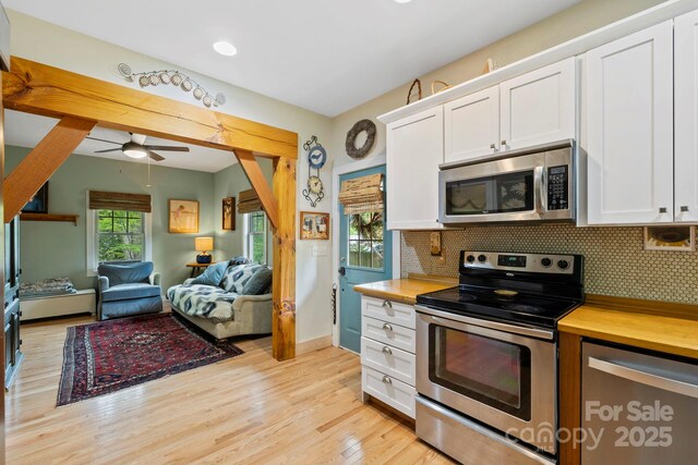 102 Altamahaw Ave, Black Mountain, NC 28711 - kitchen featuring appliances with stainless steel finishes, white cabinetry, light wood-style floors, and decorative backsplash