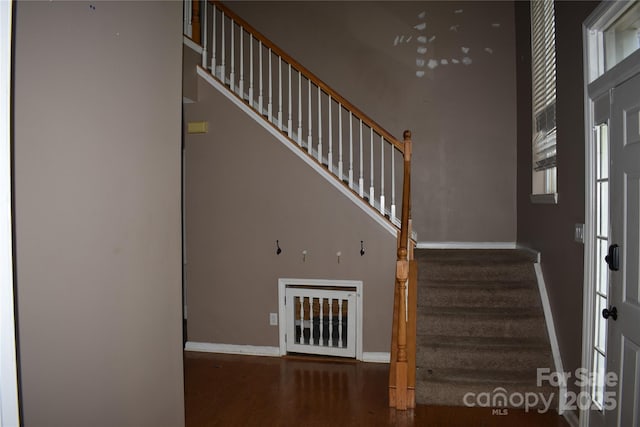 staircase with baseboards and wood finished floors