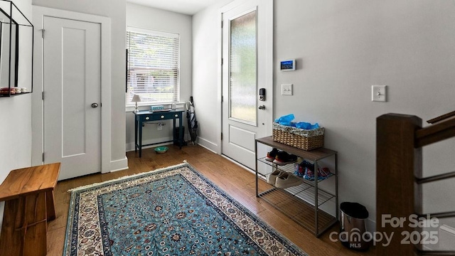 doorway to outside with baseboards and wood finished floors