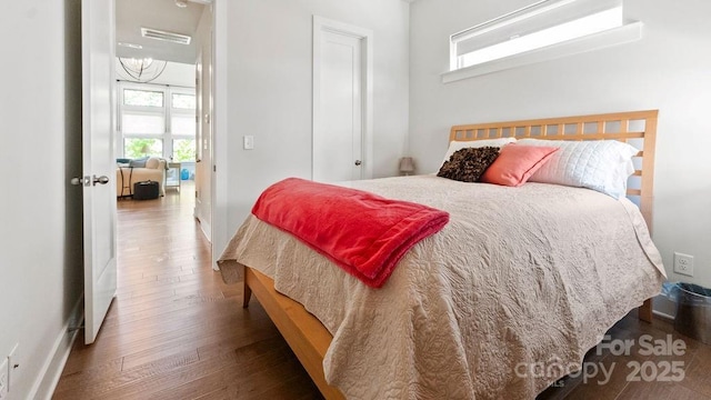 bedroom featuring baseboards, wood finished floors, and visible vents