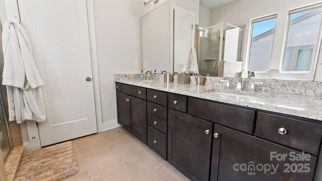 bathroom with a sink, tile patterned flooring, a stall shower, and double vanity