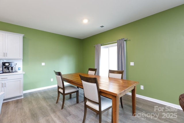 dining space with baseboards, light wood-style flooring, and recessed lighting
