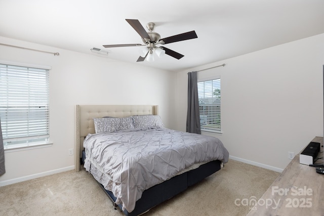 carpeted bedroom featuring baseboards, ceiling fan, and visible vents