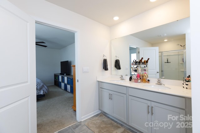 full bath with a shower stall, recessed lighting, double vanity, and a sink