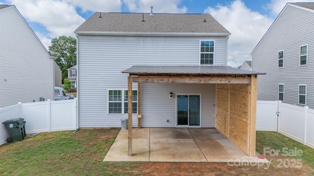 back of house featuring a gate, metal roof, a lawn, a fenced backyard, and a patio area