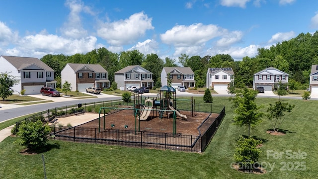 community jungle gym featuring a yard, fence, and a residential view