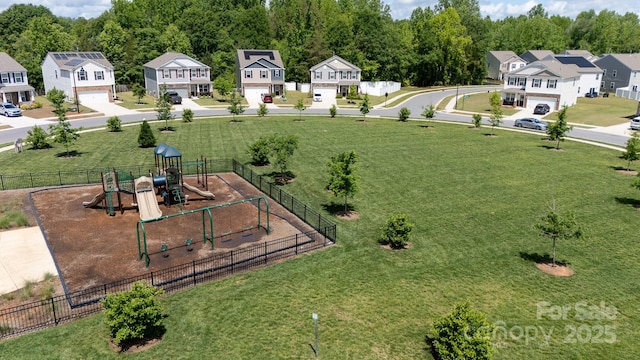 view of yard featuring a residential view, playground community, and fence
