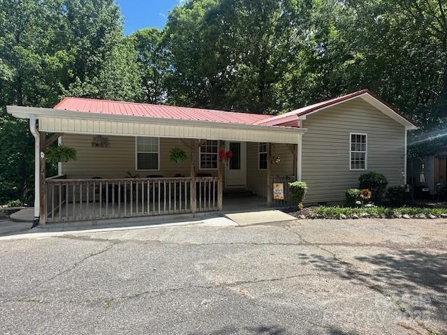 single story home with a porch and metal roof