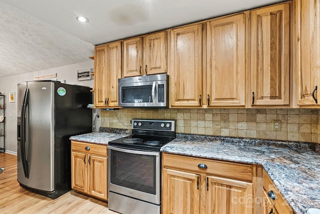 3690 Birchwood Ln, Denver, NC 28037 - kitchen with stainless steel appliances, light wood-type flooring, backsplash, a textured ceiling, and brown cabinets