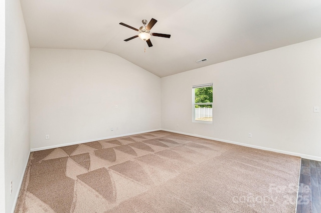 unfurnished room featuring ceiling fan, vaulted ceiling, baseboards, and visible vents