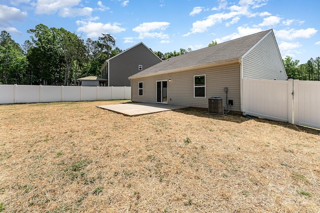 back of property featuring a lawn, a patio, a fenced backyard, and central AC unit