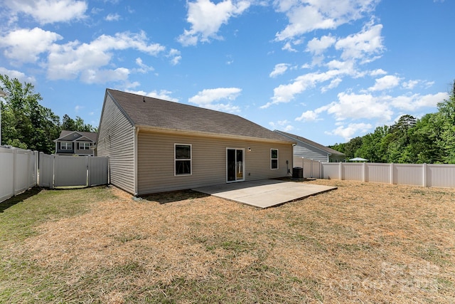 rear view of house featuring a lawn, a patio, and a fenced backyard