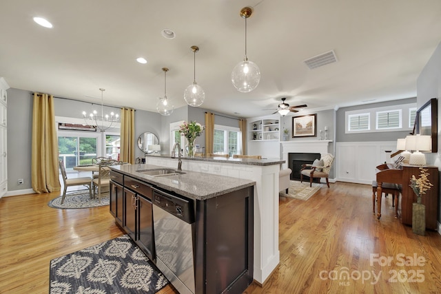 3426 Richards Xing, Fort Mill, SC 29708 - kitchen with dishwasher, a sink, an island with sink, a fireplace, and light wood-style floors