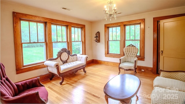 sitting room with a healthy amount of sunlight, a chandelier, and visible vents