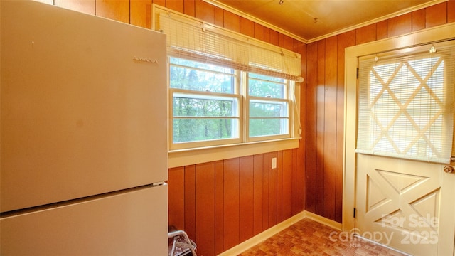 entryway with crown molding and wooden walls