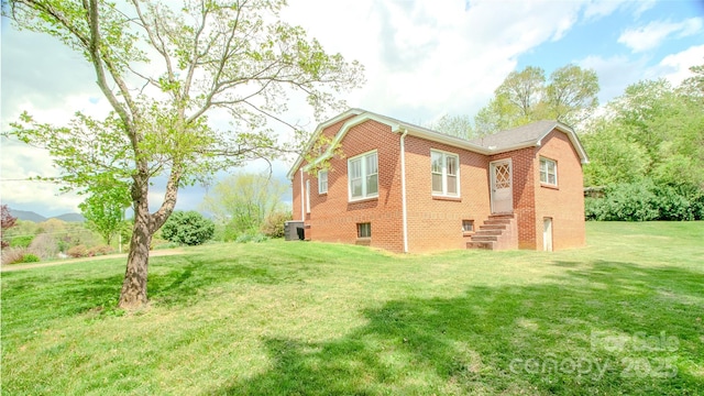 view of property exterior with a lawn and brick siding