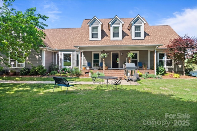 back of property featuring a porch, roof with shingles, and a yard