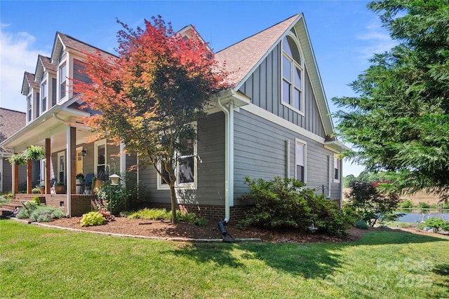 view of home's exterior featuring board and batten siding, a porch, a yard, and a shingled roof