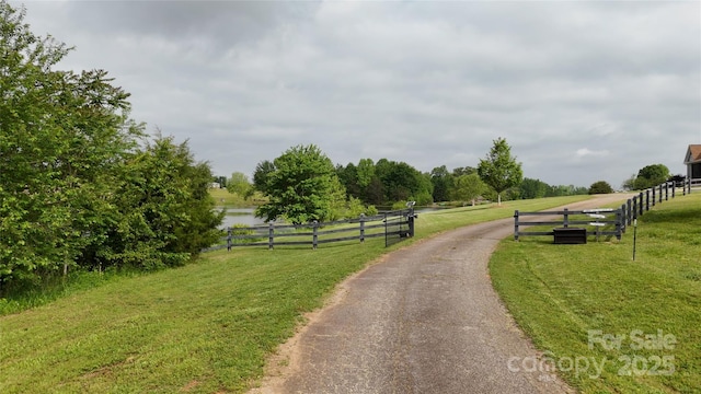 view of asphalt driveway featuring a rural view