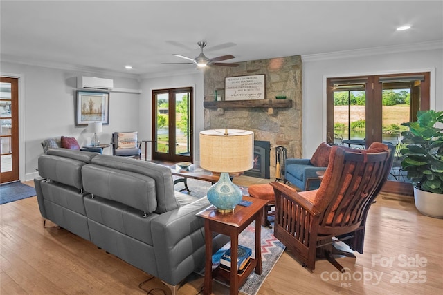 living room with french doors, a wall mounted AC, light wood finished floors, ornamental molding, and recessed lighting